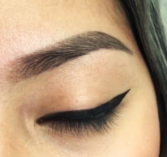 A close up of a woman 's eye with black eyeliner.