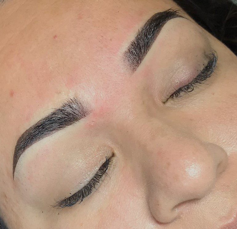 A woman with her eyes closed and brows drawn.