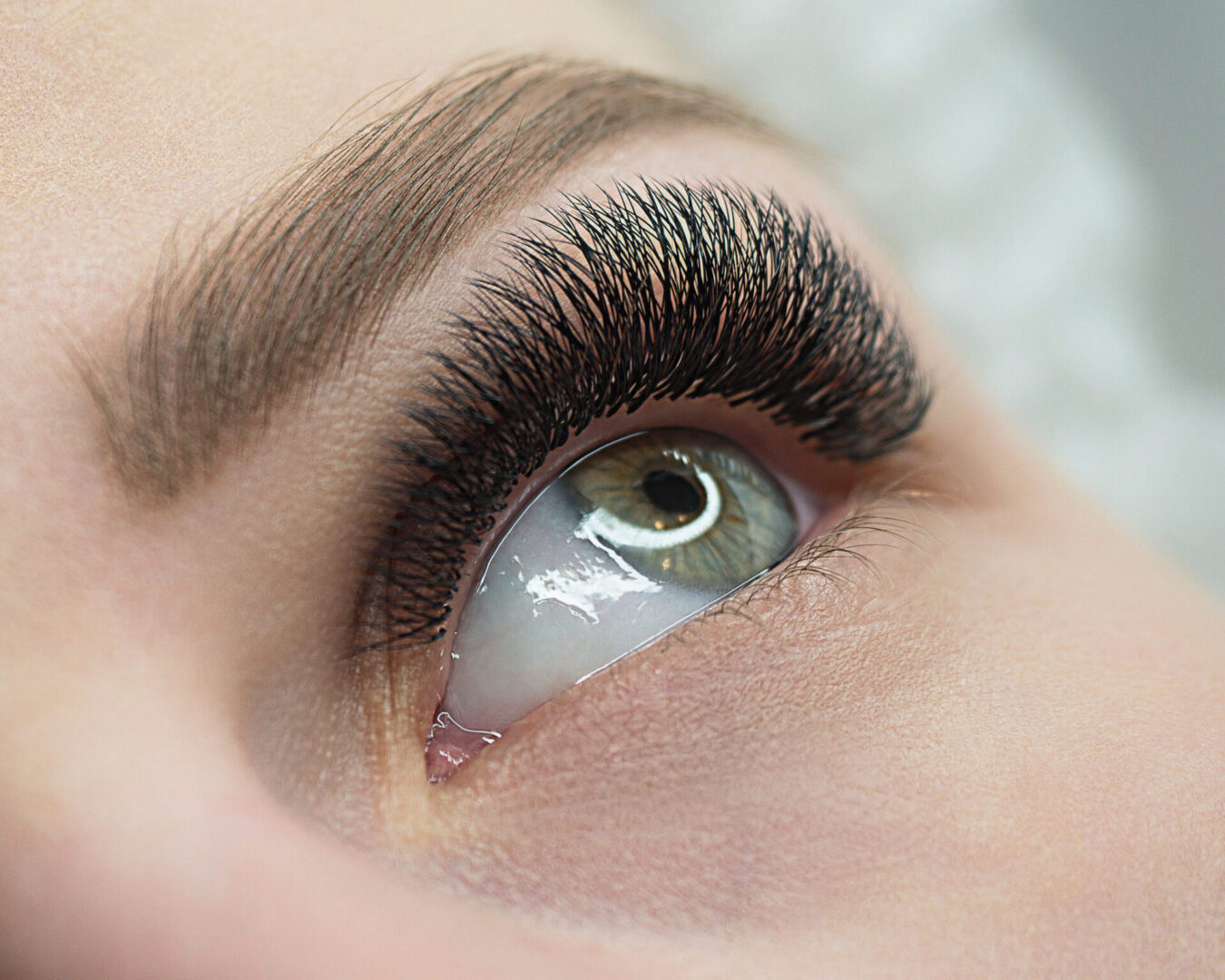 A close up of a person 's eye with long eyelashes