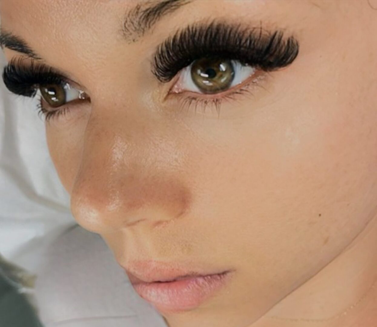 A woman with long eyelashes and green eyes.