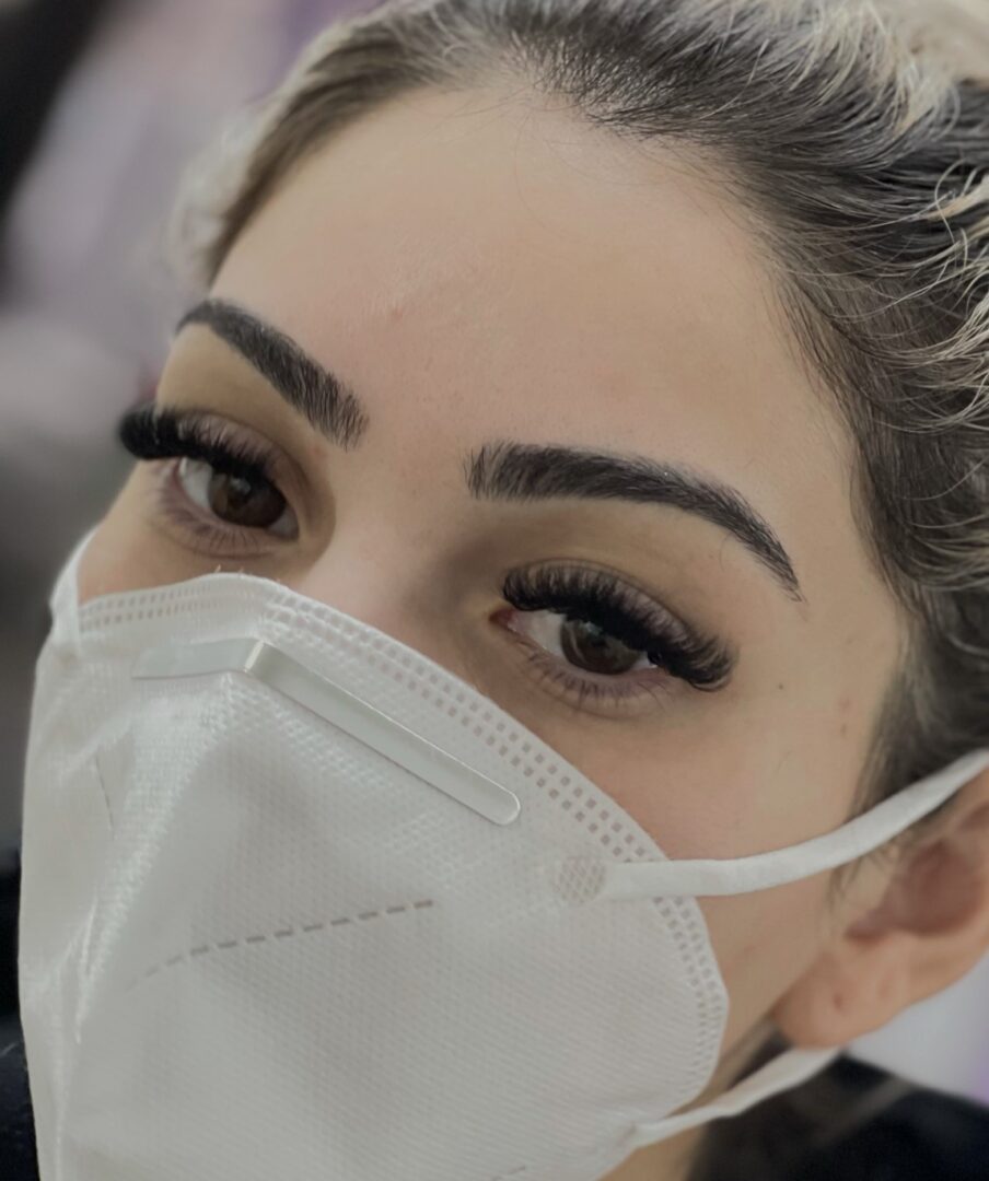 A woman wearing a face mask with her eyes closed.