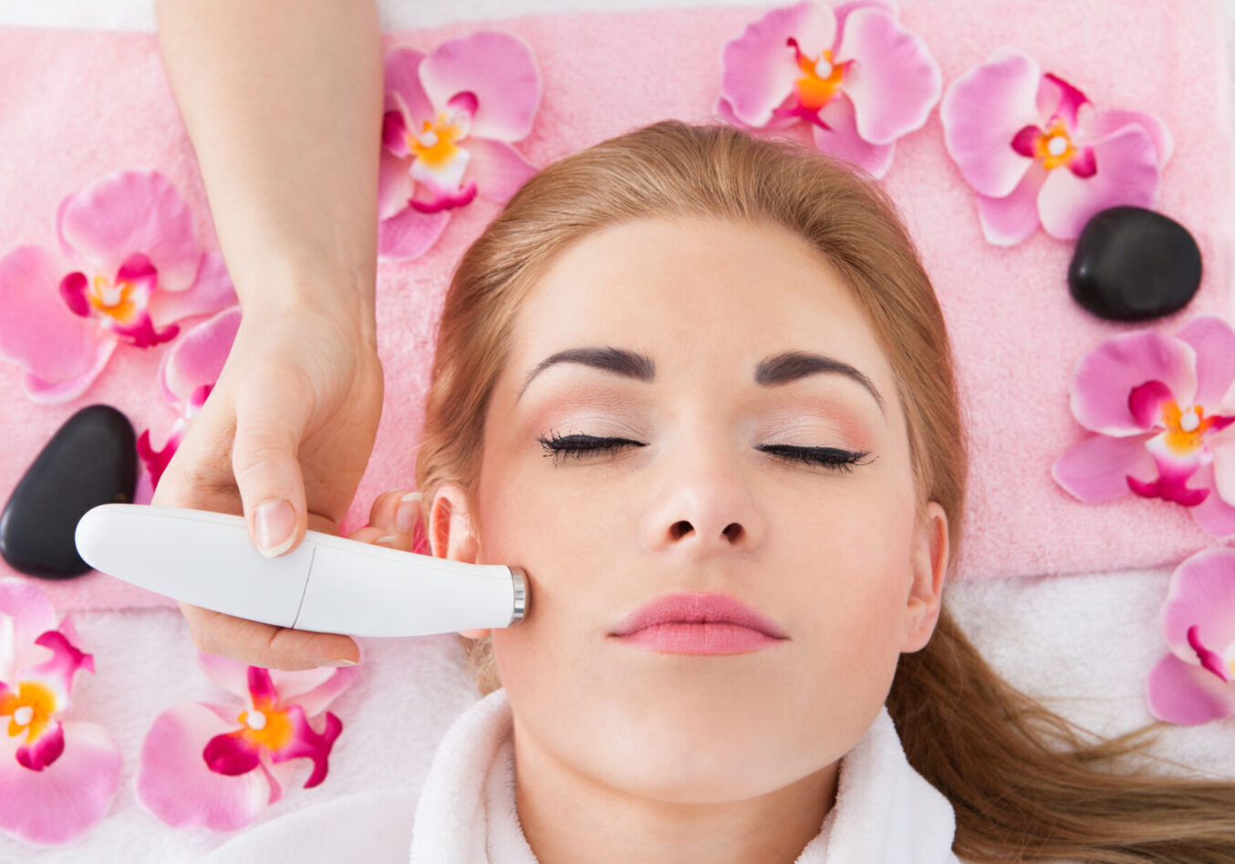 A woman getting her face cleaned by an esthetician.